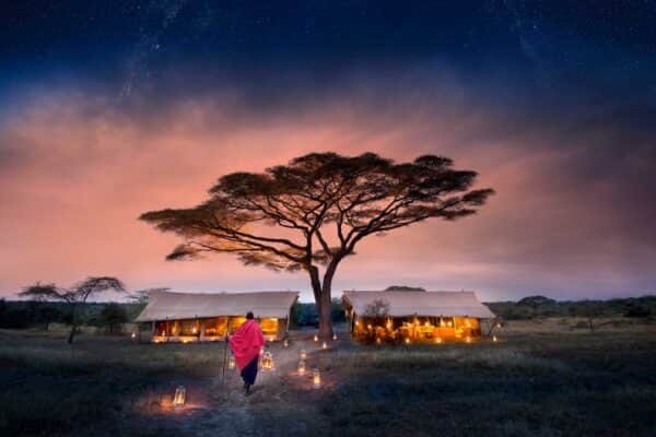 Camping Safari - TravelLife - Safaris in Tansania - Tanzania Serengeti Under Canvas SUC Gästebereich, Camp von aussen mit Laternenweg und Massai
